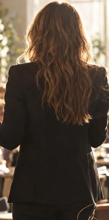 A speaker on stage, seen from behind, addressing a full room
